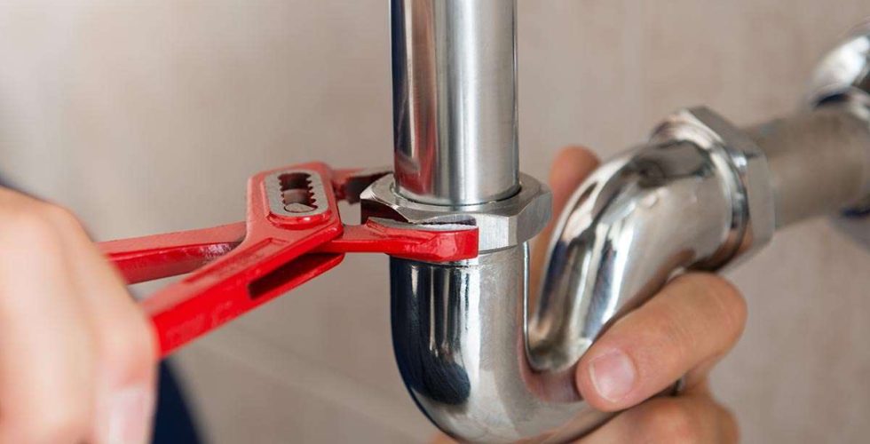 closeup-plumber-fixing-pipe-with-wrench